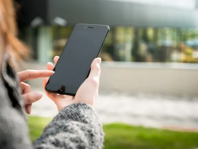A woman on her mobile phone outdoors making a call.